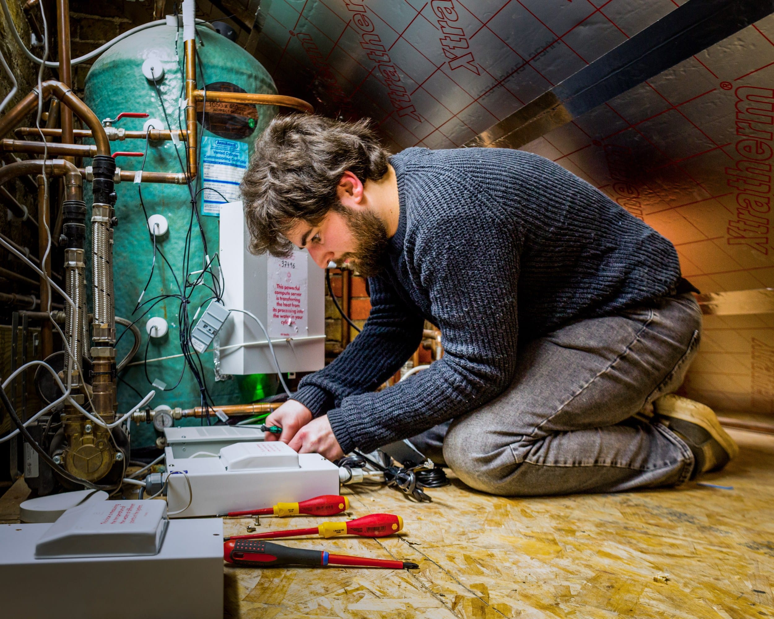 Эндрю на коленях работает на чердаке