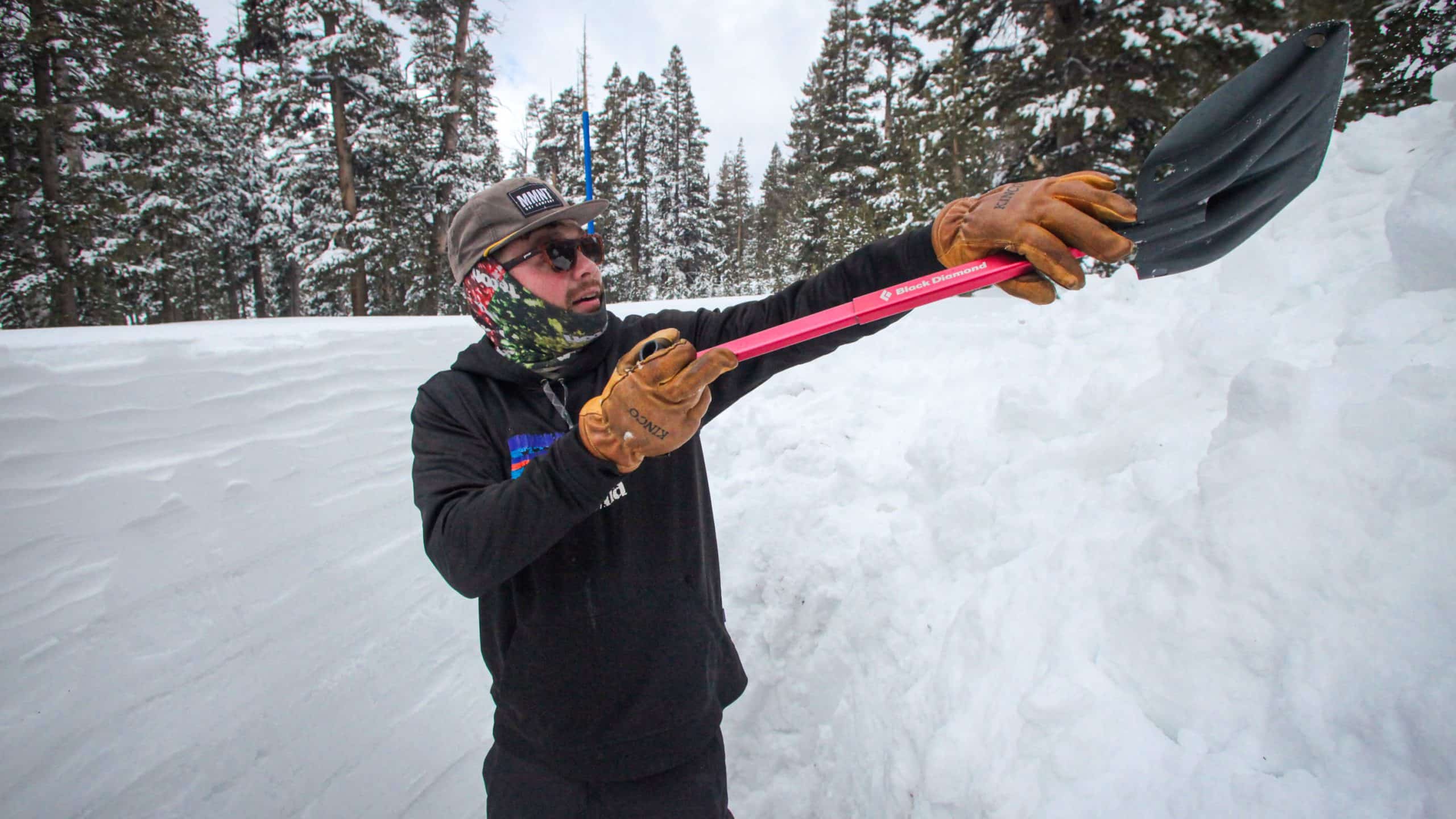 Человек поднимает снеговую лопату на уровень головы